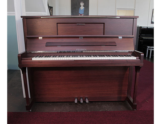 Brand new, Feurich Model 123 upright piano with a satin, walnut case, LED Lighting and chrome fittings. Piano features a high speed KAMM action that allows extremely fast repetition. Piano has an eighty-eight note keyboard and three pedals. 