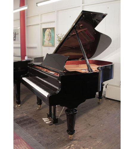 A 2021, Toyama TC-187 grand piano for sale with a black case and turned, faceted legs.  Piano has an eighty-eight note keyboard and a two-pedal lyre. 