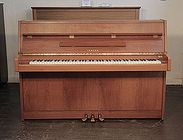 A 1980, Yamaha M5J upright piano with a satin, walnut case