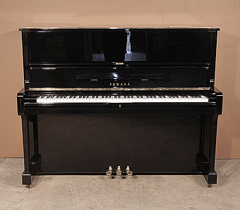 A 1975, Yamaha U1 upright piano with a black case and polyester finish. Piano has an eighty-eight note keyboard and three pedals. 