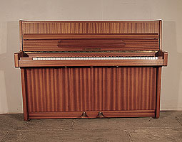 Alexander Herrmann upright piano with a satin, mahogany case. Piano has an eighty-five note keyboard and and two pedals