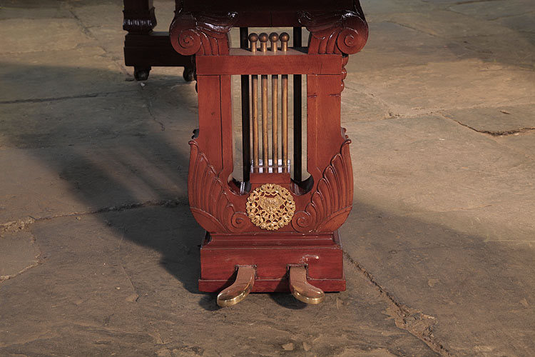 Ibach two-pedal piano lyre features four brass rods and is flanked with carved wings. A circular filigree ormolu mount sits at its base featuring intertwined flowers and tendrils with a central cherubs head 