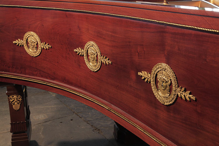Ibach piano cabinet with repeated circular ormolu mounts featuring crowned, greek female heads with a laurel leaf wreath and corn stalks