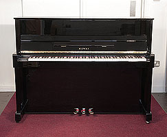 Reconditioned,  2000, Kawai CX-5H upright piano with a black case and brass fittings 