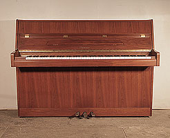 Ottostein CS-108 upright piano with a crown cut, satin, walnut case. Piano has an eighty-eight note keyboard and and three pedals