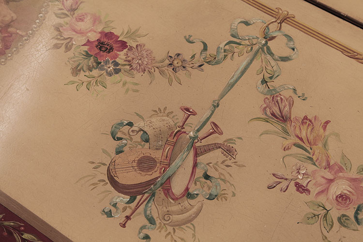 Hand-painted detail of musical instruments suspended from a ribbon