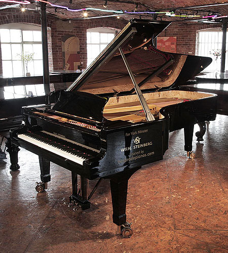 Brand new, Wilh Steinberg WS-D275 concert grand piano with a black case and brass fittings. Piano has dual casters and brakes for ease of movement. Piano has an eighty-eight note keyboard and three-pedal lyre.