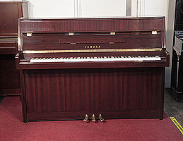 A 1992, Yamaha M108 upright piano with a mahogany case and polyester finish. Piano has an eighty-eight note keyboard and three pedals. 