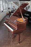 A Bentley baby grand piano for sale with a walnut case and spade legs. Piano has an eighty-eight note keyboard and a three-pedal lyre