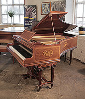 Artcase,  1894, Broadwood grand piano with a fiddleback mahogany case and tapered fluted legs attached with a cross stretcher. Cabinet inlaid with oval panels featuring muical instruments and foliage and flowers and satinwood crossbanding and stringing accents. 