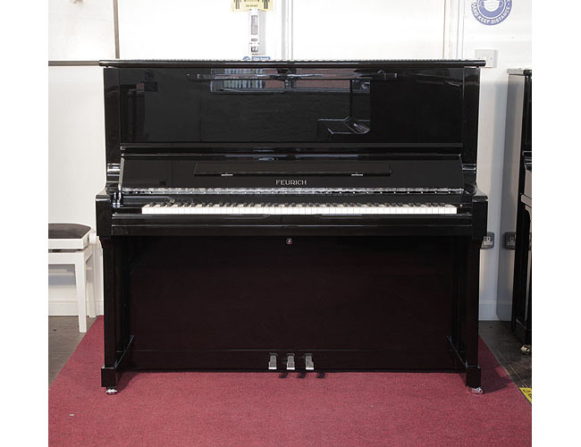 Brand new, Feurich Model 133 Concert upright piano with a black case and chrome fittings. Cabinet features and extendable LED strip light and a slow fall mechanism. Piano has an eighty-eight note keyboard and three pedals. 