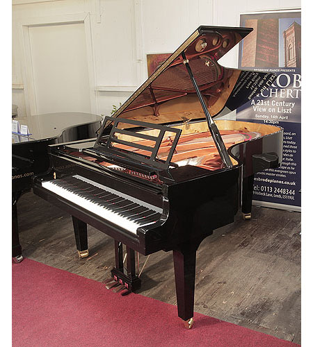 Brand new, Feurich model F218 Concert I grand piano with a black case and brass fittings.   Piano has an eighty-eight note keyboard and a three-pedal piano lyre. 