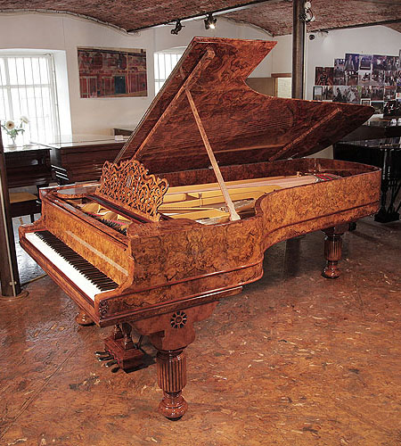 Rebuilt, 1881, Steinway & Sons Model D concert grand piano with an exquisite, burr walnut case and brass fittings. The music desk is an arabesque cut-out design of stylised foliage with a central lyre motif. The piano legs are fluted, barrels with a carved, stylised sunflower on the pediment