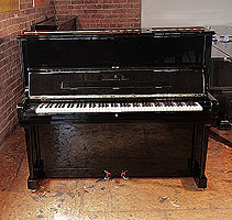 A 1986, Steinway Model V upright piano with a black case and brass fittings