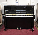 Piano for sale. A brand new, Wilh. Steinberg Model AT-K23 upright piano with a black case and brass fittings. 