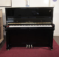 A brand new, Wilh. Steinberg Model AT-K30 upright piano with a black case and brass fittings