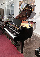 A 1990, Yamaha G1 baby grand piano for sale with a black case and spade legs. Piano has an eighty-eight note keyboard and a three-pedal lyre.