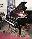 Piano for sale. Reconditioned, 1988, Yamaha GH1 baby grand piano for sale with a black case and square, tapered legs. Piano has an eighty-eight note keyboard and a three-pedal lyre.