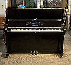 Piano for sale. A 1974, Yamaha U1 upright piano with a black case and polyester finish. Piano has an eighty-eight note keyboard and three pedals. 