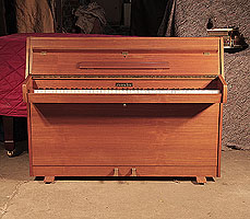 Zender upright piano with a polished, walnut case. Piano has an eighty-five note keyboard and two pedals. 