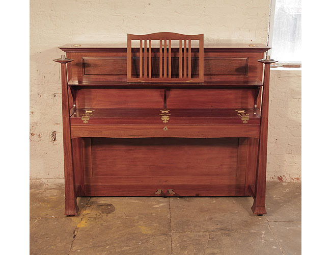 Arts and Crafts style, 1899, Bechstein upright piano with a walnut case. Cabinet features sizeable, brass hinges. The large sculptural legs taper to candlesticks. Design by Walter Cave.