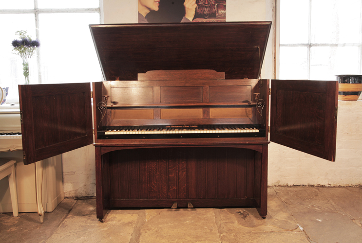  Arts and Crafts style, 'Manxman' Broadwood Piano with an Oak Case and Brass Strap Hinges. Designed by M. H. Baillie Scott..