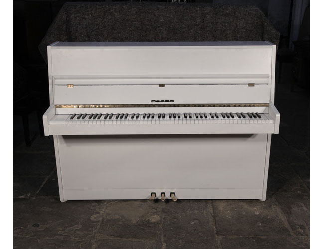 Pre-owned, 1979, Fazer upright piano with a matt, white case and brass fittings. Piano has an eighty-eight note keyboard and three pedals. 