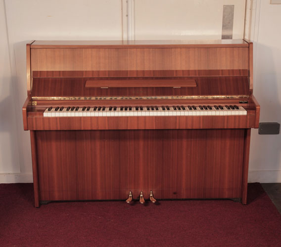 Piano for sale. A 1981, Kawai CE-7N upright piano for sale with a satin, walnut case and brass fittings. Piano has an eighty-eight note keyboard and three pedals. 