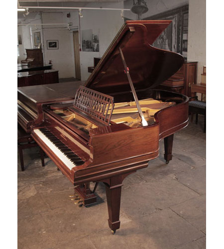 Antique, 1900, Steinway Model A grand piano with a polished, rosewood case and spade legs. The cut-out music desk is in a geometric design featuring interlocking ovals.  Piano has an eighty-eight note keyboard and a three-pedal lyre. 