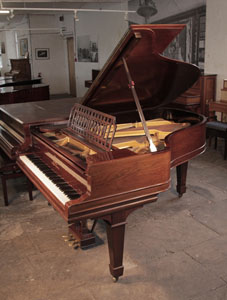 Antique, 1900, Steinway Model A grand piano with a polished, rosewood case and spade legs. The cut-out music desk is in a geometric design featuring interlocking ovals. Piano has an eighty-eight note keyboard and a three-pedal lyre with brass footplate.
