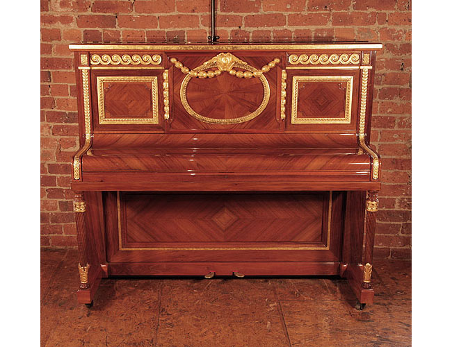 A 1912, Steinway Vertegrand upright piano for sale with a quartered walnut case. Cabinet features carvings of rolling waves, strapwork and beading highlighted with gold.