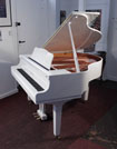 Piano for sale. A 2020, Yamaha GB1 baby grand piano for sale with a white, gloss case and square, tapered legs. Piano has an eighty-eight note keyboard and a three-pedal lyre..