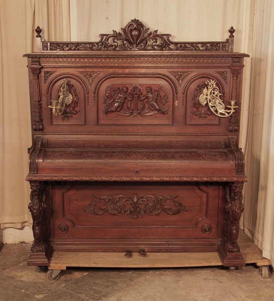 Neoclassical style, Francke upright piano for sale with an ornately carved, oak case and griffin legs. Cabinet features carved  angels, lions heads, acanthus and openwork arcading.. Piano has an eighty-five keyboard and two pedals.