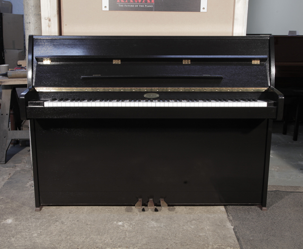Pre-owned, 1995, Kemble upright piano with a black polished case and brass fittings. Piano has an eighty-eight note keyboard and two pedals. 