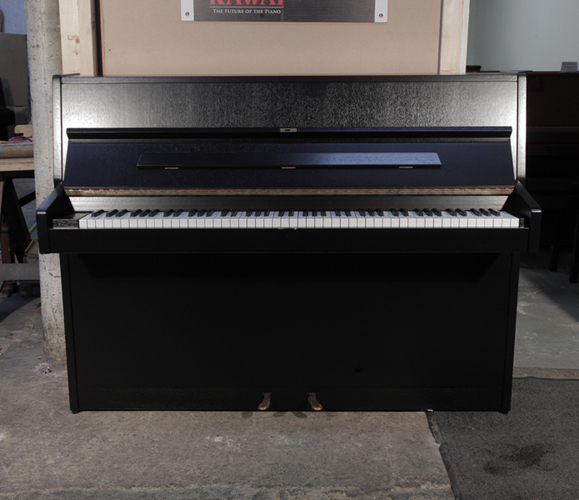 Pre-owned, 1972, Sauter 108 upright piano with a black, polished case and brass fittings. Piano has an eighty-eight note keyboard and two pedals.