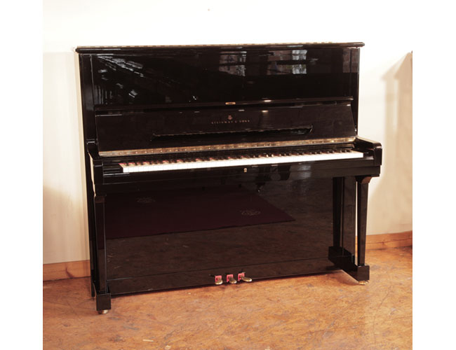 A 1990, Steinway Model K upright piano for sale with a black case and brass fittings. Piano has an eighty-eight note keyboard and three pedals 