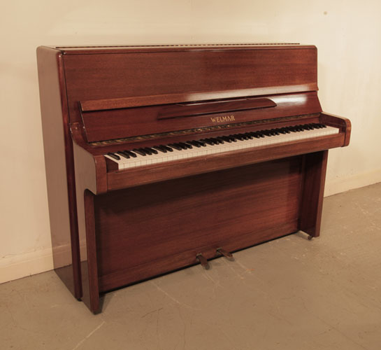 Reconditioned, 1970, Welmar  upright piano with a polished, mahogany case and brass fittings. Piano has an eighty-eight note keyboard and and two pedals.  
