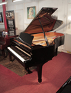 Piano for sale. Reconditioned, 2000, Yamaha C6 grand piano for sale with a black case and spade legs. Piano has an eighty-eight note keyboard and a three-pedal lyre. .