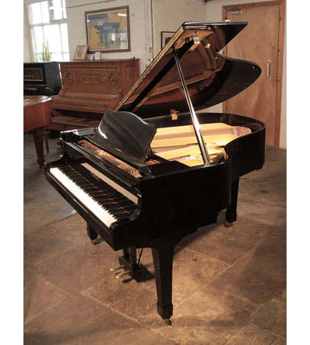 A 1982, Yamaha G2 grand piano with a black case and spade legs. Piano has an eighty-eight note keyboard and a three-pedal lyre. 