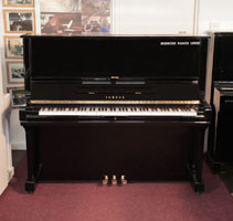 Reconditioned,  1974, Yamaha U3 upright piano for sale with a black case and brass fittings. Piano has an eighty-eight note keyboard and three pedals. 