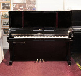 A 2019, YUS5 SH2 upright piano for sale with a black case and brass fittings. Piano has a fitted silent system. Piano has an eighty-eight note keyboard and three pedals.   