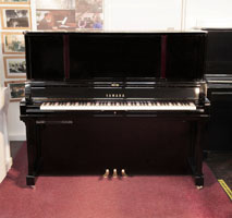 A 2019, YUS5 SH2 upright piano for sale with a black case and brass fittings. Piano has an eighty-eight note keyboard and three pedals. 