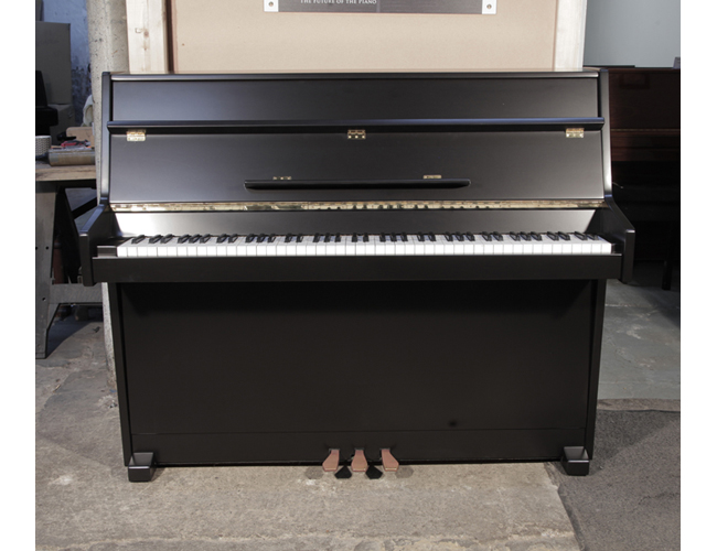 Pre-owned, 1988, Young Chang U-109 upright piano with a black, satin case and brass fittings. Piano has an eighty-eight note keyboard and two pedals. 