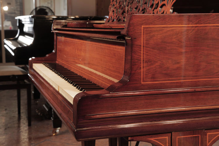 Steinway Model O serpentine piano cheek in rosewood with satinwood stringing accents. The dual linear case moulding wraps around the base of the piano cabinet.