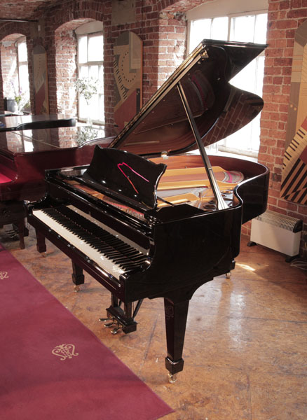 A 1996, Steinway Model M grand piano for sale with a black case and spade legs. Piano has an eighty-eight note keyboard and a three-pedal lyre. 