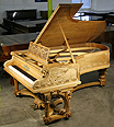 The Golden Age of Pianos Exhibition. An intricately carved Bechstein Model C grand piano with an ornately carved, walnut case. Cabinet features carvings of two swans on the water on piano cheeks. Twisted around the rear piano leg is a two-headed serpent dragon. Professor Max Koch created the design for this Bechstein based on themes found in Richard Wagner's great Ring Cycle works.